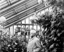 Mr. Kennedy in green house without hat Original caption: Mr. Kennedy in green house without hat
