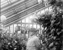 Mr. Kennedy in greenhouse with hat Original caption: Mr. Kennedy in greenhouse with hat