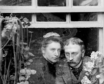Uncle Alick and Aunt Emmy through greenhouse window Original caption: Uncle Alick and Aunt Emmy through greenhouse window