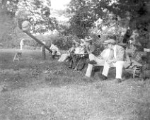 Family in the orchard. two on see-saw Original caption: Family in the orchard. two on see-saw