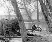 Father in rowing boat on lake by weir Original caption: Father in rowing boat on lake by weir