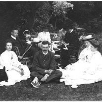Ladies and gents having tea on lawn Original caption: Ladies and gents having tea on lawn