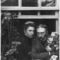 Uncle Alick and Aunt Emmy through greenhouse window Original caption: Uncle Alick and Aunt Emmy through greenhouse window