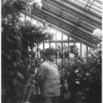 Mr. Kennedy in greenhouse with hat Original caption: Mr. Kennedy in greenhouse with hat