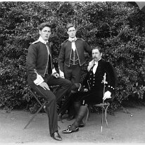 Father in court dress, Gilbert & Reggie in uniform Original caption: Father in court dress, Gilbert and Reggie in uniform