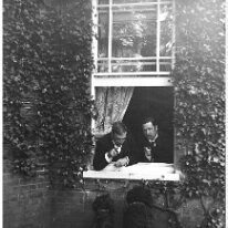 Father & Mr. Long in window with dogs Original caption: Father and Mr. Long in window with dogs