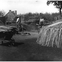 Charcoal burners stack and wheelbarrow Original caption: Charcoal burners stack and wheelbarrow