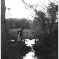 Mr. H. + girl by lake Sedgeford Park Original caption: Mr. H. + girl by lake