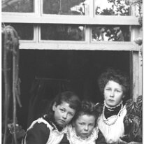 3 girls looking in from greenhouse window Original caption: 3 girls looking in from greenhouse window