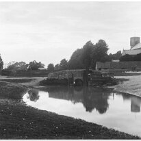 Village bridge scene with Sedgeford church West Hall Farm, bridge, pond, barns and Sedgeford church beyond Original caption: Village bridge scene
