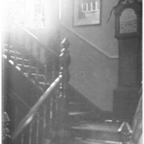 Interior with longcase on strairs Inscription on reverse in Woodgate album: Staircase opposite dining room door Original caption: Interior with longcase on strairs