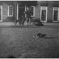 Father with dogs on lawn Sedgeford Hall Original caption: Father with dogs on lawn