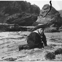 Splat Cove Original caption: Boy in sailor suit on beach