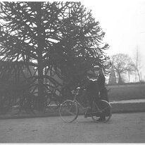 Boy in sailor suit on a bicycle with a girl Original caption: Boy in sailor suit on a bicycle with a girl