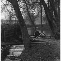 Father in rowing boat on lake by weir Original caption: Father in rowing boat on lake by weir