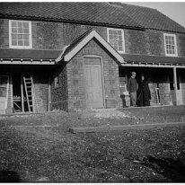 Father and Rev Ogle and wife outside Brookdale Church Lane, Sedgeford Original caption: Father and 2 others by a house being built