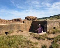 A pillbox on the coast path. Part of the pillbox has already fallen into the sea leaving a large hole inside.